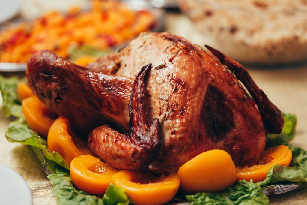 A close-up image of a roasted turkey with peaches.