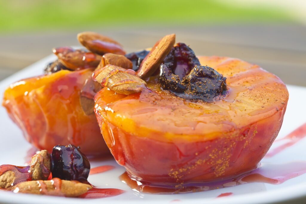 A plate of poached peaches with cinnamon and almonds.