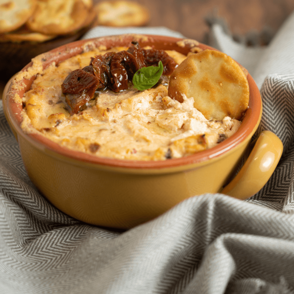 Small ceramic cooking vessel filled with a baked cheese dip.