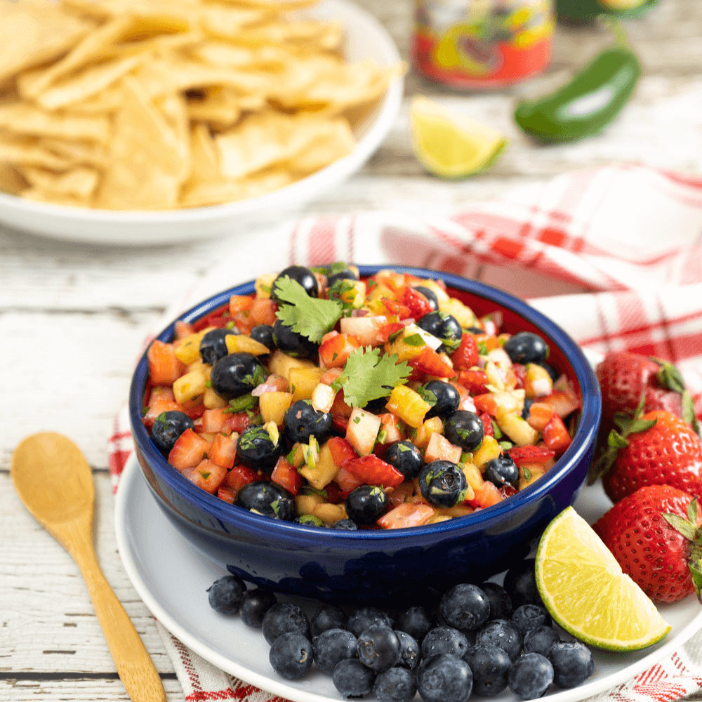 Blue bowl filled with fruit salsa made with pineapple and berries.