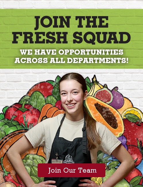 A recruitment poster featuring a young woman wearing a farm Boy work apron and smiling, standing in front of a colourful illustrated background of various fruits and vegetables. The poster reads, "JOIN THE FRESH SQUAD" at the top, followed by "WE HAVE OPPORTUNITIES ACROSS ALL DEPARTMENTS!" Below the woman, there is a red button that says "Join Our Team."