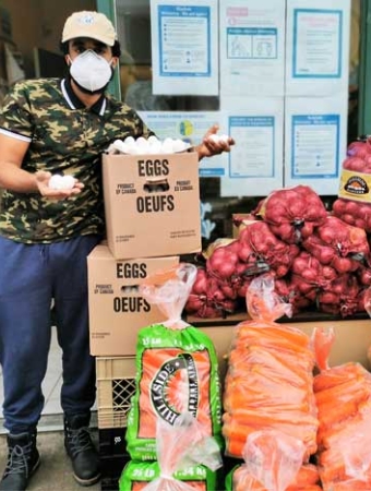 person standing next to boxes of groceries