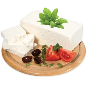 A block of feta cheese on a circular serving tray. The tray has a few olives, tomatoes and herbs as garnish.