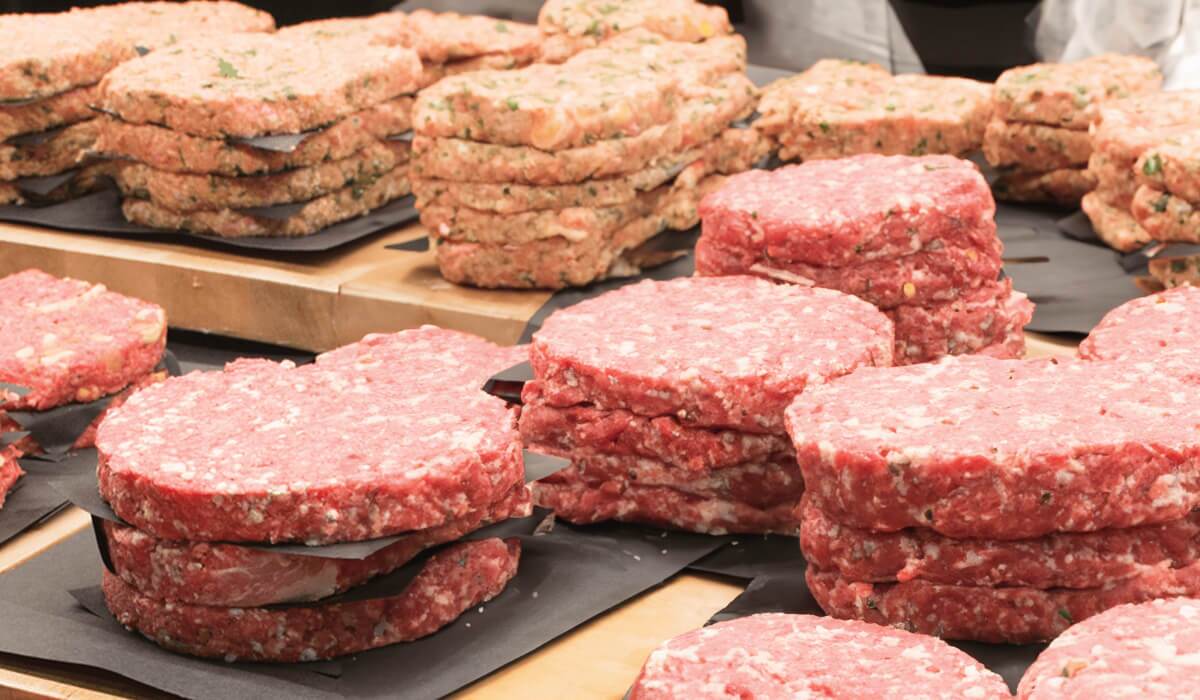 raw gourmet burgers in butcher case