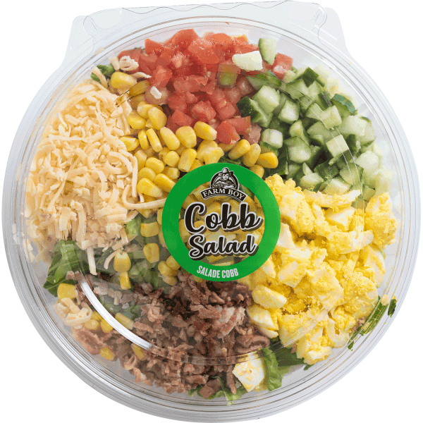 Fresh salad: Farm Boy™ Cobb Salad container. The salad has segments of shredded cheese, tomatoes, cucumbers, corn, egg, and bacon visible.