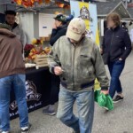 Man walks away from Farm Boy event table with a coupon.