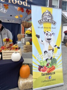 Close up of the Farm Boy event banner alongside pumpkins.