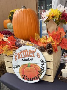 A fall harvest display and a vintage sign saying Farmer's Market.