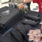 Close up of bags and hats alongside free food giveaways.