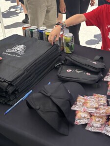 Close up of bags and hats alongside free food giveaways.