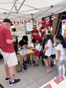 Families waiting in line to have their faces painted by a professional.