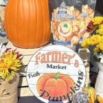 Fall display of a pumpkin and a vintage Farmer's Market sign.