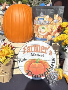 Fall display of a pumpkin and a vintage Farmer's Market sign.