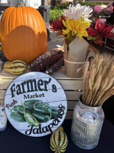 Fall display of a pumpkin and a vintage Farmer's Market sign.