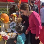 Women and child looking closely at the free Farm Boy samples.