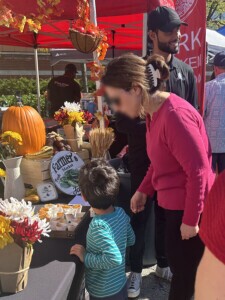 Women and child looking closely at the free Farm Boy samples.