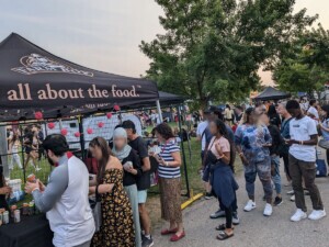 A long line of people stand waiting for a free Farm Boy drink.