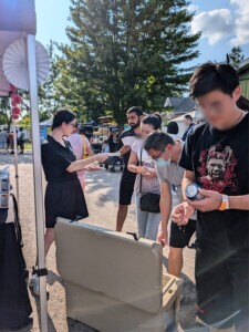 Small crowd of people gather around the event table to see the different flavours.