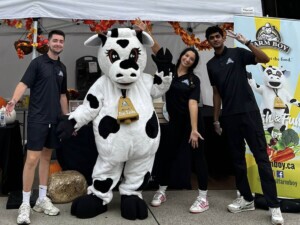 Farm Boy employees posing with Farm Boy's mascot Lulu in front of the event table.