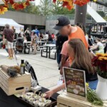 Festival goers taking a free Farm Boy sample from the event table.