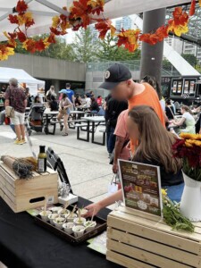 Festival goers taking a free Farm Boy sample from the event table.