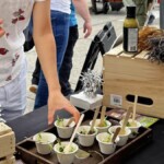 Close up of one customer taking a free Farm Boy sample from the event table.