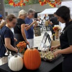 Festival goers walking by the Farm Boy event table.