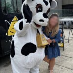 Farm Boy's mascot Lulu posing for a photo with a young lady.