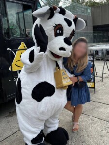 Farm Boy's mascot Lulu posing for a photo with a young lady.