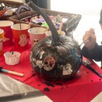 Spooky black pumpkin with halloween decorations on it. 