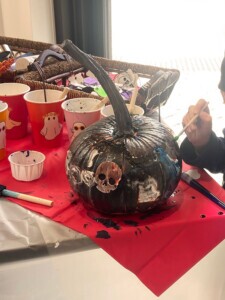 Spooky black pumpkin with halloween decorations on it. 