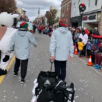 Two Farm Boy team members and Lulu walking in the parade. 