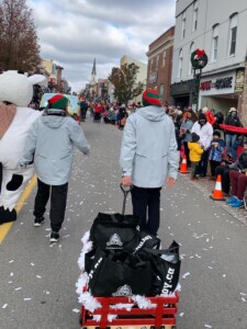 Two Farm Boy team members and Lulu walking in the parade. 