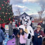 Wide shot of the event with a huge Christmas tree in the background.