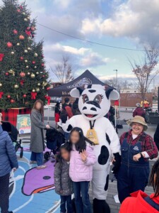 Wide shot of the event with a huge Christmas tree in the background.