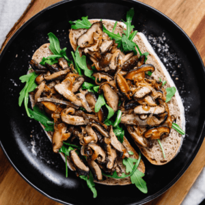 Top view of two vegan sandwiches with fresh arugula, fried shiitake mushroom and shallot onion.