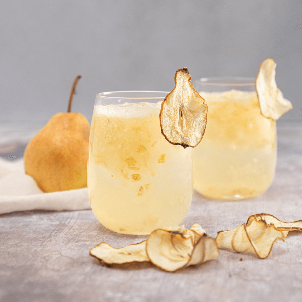 Two glasses of pear citrus Chardonnay mocktail garnished with pear chips.