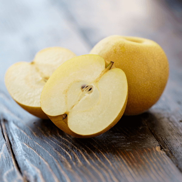 Asian pear sliced and one whole shot on wood background with shallow depth of focus.